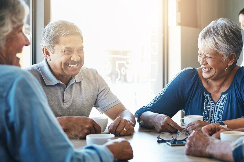 Residents smiling and talking while participating in a group game at a senior living community